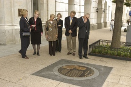Visitors examine a medallion on the Extra Mile Volunteer Pathway